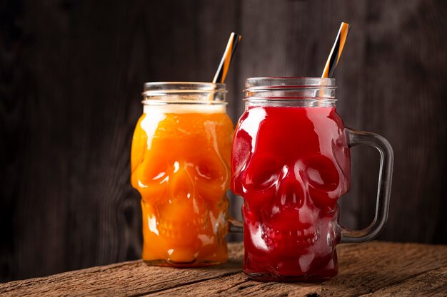 Halloween-Getränk Kürbisgetränk und Blutgetränk im Totenkopfglas