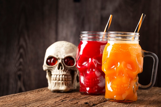 Halloween-Getränk Kürbisgetränk und Blutgetränk im Totenkopfglas