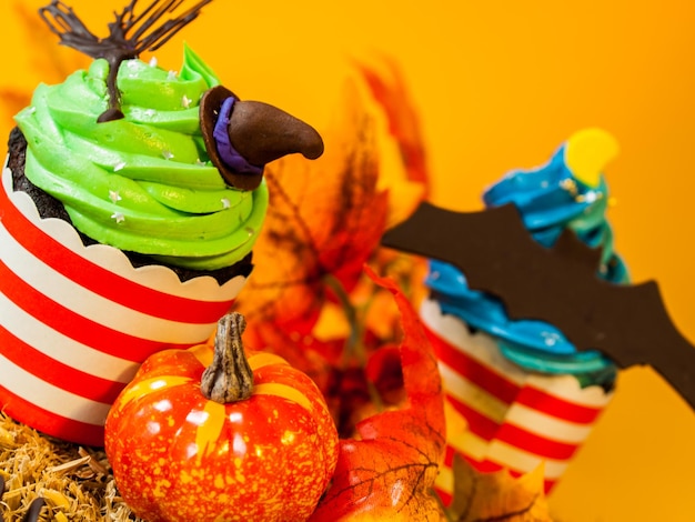 Halloween-Gourmet-Cupcakes mit orangefarbenem Hintergrund des Feiertagsdekors.