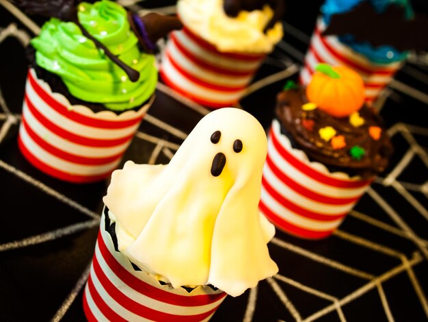 Halloween-Gourmet-Cupcakes mit schwarzem Hintergrund des Feiertagsdekors.