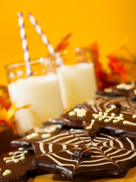 Halloween-Gourmetplätzchen mit orangefarbenem Hintergrund des Feiertagsdekors.