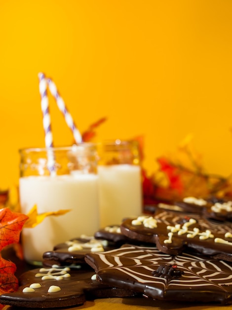 Halloween-Gourmetplätzchen mit orangefarbenem Hintergrund des Feiertagsdekors.