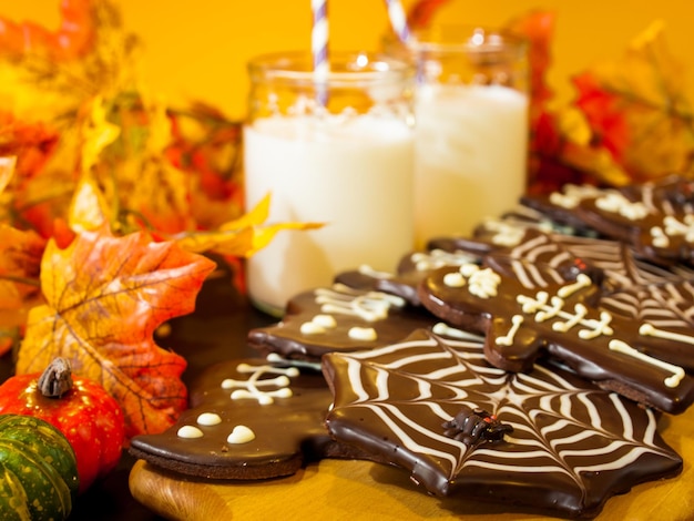 Halloween-Gourmetplätzchen mit orangefarbenem Hintergrund des Feiertagsdekors.