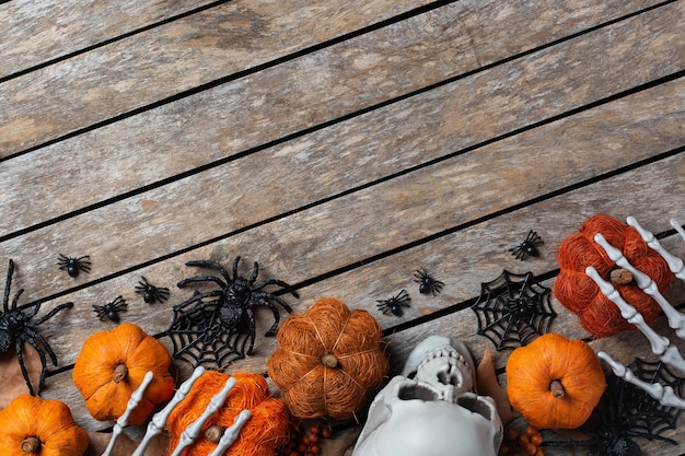 Halloween-Grüßkarte mit Kürbisschädeln, knochigen Händen und Blättern