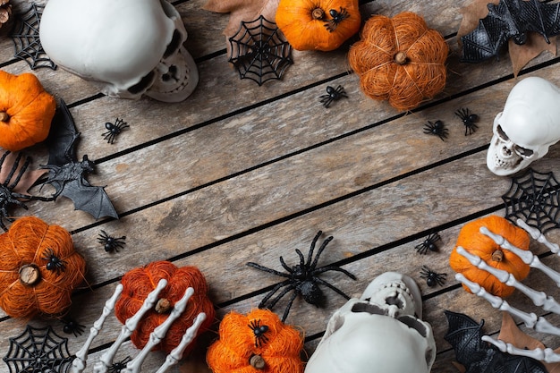 Halloween-Grüßkarte mit Kürbisschädeln, knochigen Händen und Blättern