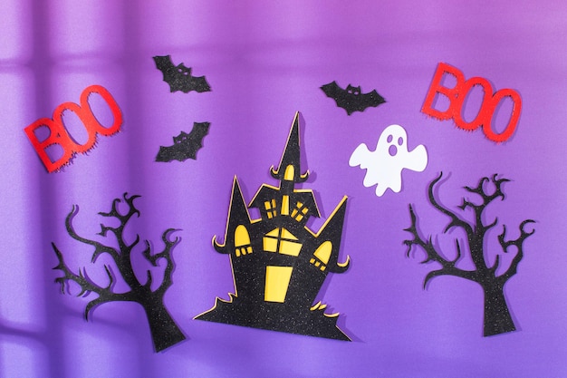 Halloween-Hintergrund auf lila Hintergrund mit Farbverlauf und Schatten Ein Spukhaus mit Fledermäusen