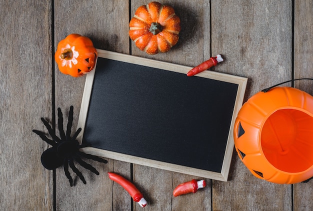 Halloween-Hintergrund mit Kürbisen, Hexenhut, Spinne, Fingern und Tafel