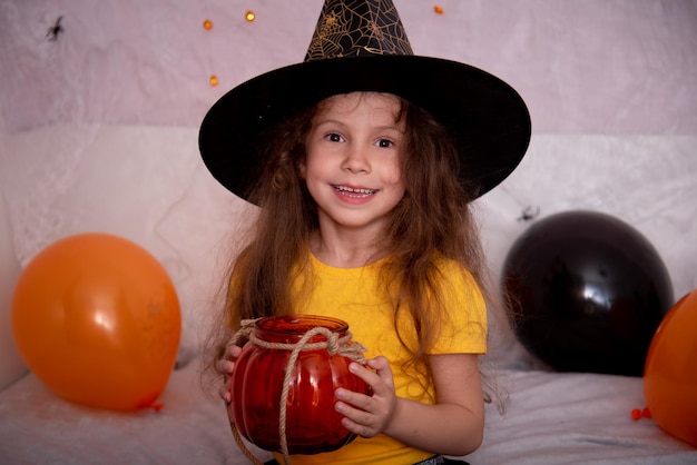 Halloween infantil Una niña sonriente con un frasco de vidrio se prepara para celebrar