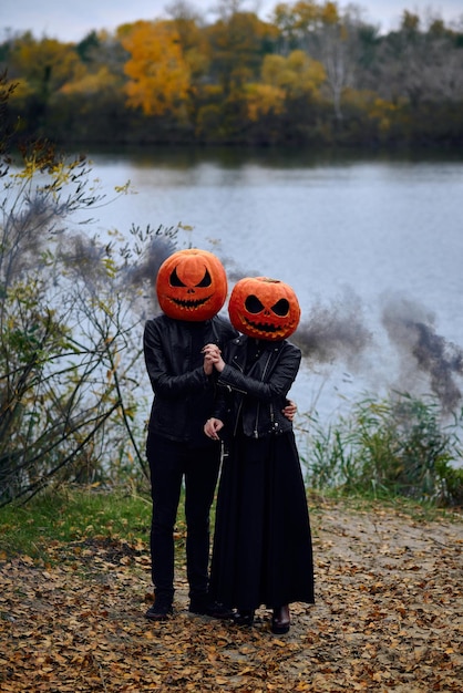 Halloween-Junge und Mädchen mit Kürbissen auf ihren Köpfen