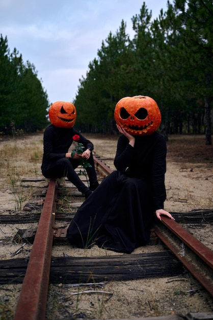Halloween-Junge und Mädchen mit Kürbissen auf ihren Köpfen