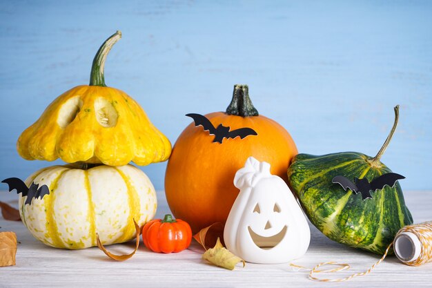 Halloween-Komposition, Kürbisse und Fledermäuse auf Holzuntergrund.