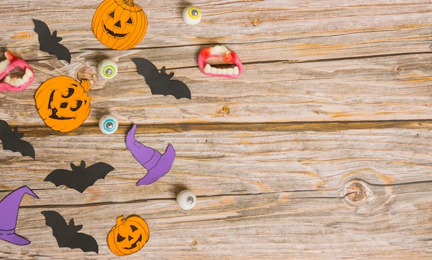 Halloween-Komposition, Papierfiguren und Bonbons auf Holzhintergrund