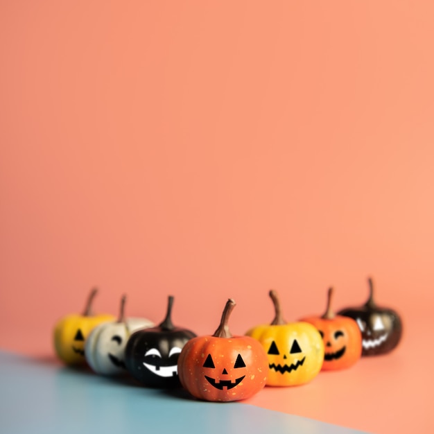 Foto halloween-konzept, kürbis mit lächelngesicht auf pastellfarbhintergrund.