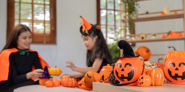 Halloween-Konzept Mutter und Tochter bereiten sich darauf vor, zu Hause zusammen schön geschmückt zu feiern