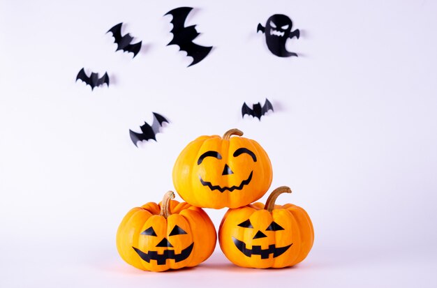 Halloween-Konzept. Orange Geisterkürbise und Menge der schwarzen Papierhiebe