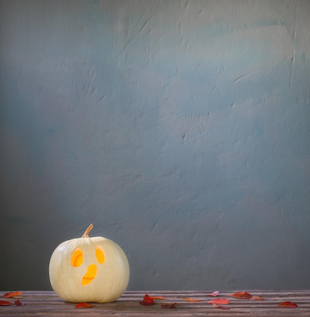 Foto halloween-kürbis auf holztisch auf dunkelblauem hintergrund