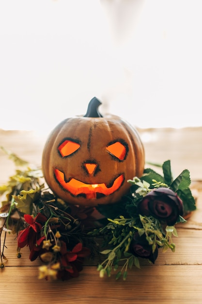 Foto halloween-kürbis mit blumen und lichtern.