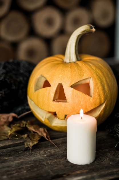 Halloween-Kürbis mit Kaffeekerze auf Holz.