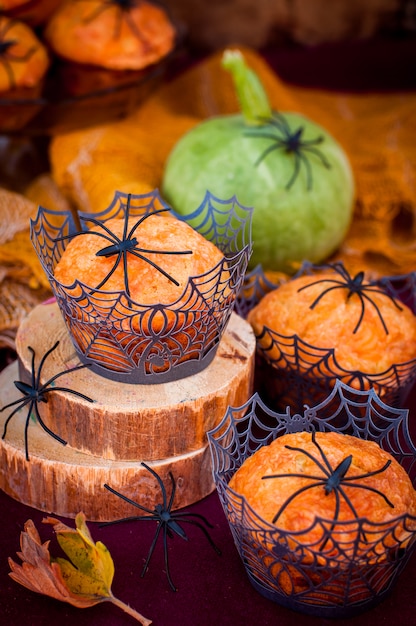 Halloween-Kürbis-Muffins verziert mit Spinnen und Spinnennetz