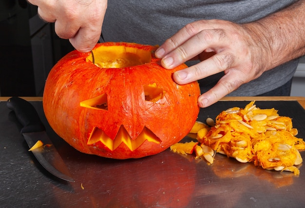 Halloween Kürbis Schneideprozess, Prozess der Herstellung von Jack-o-Laterne. Wie man zu Hause eine Kürbislaterne macht - Schritt für Schritt.