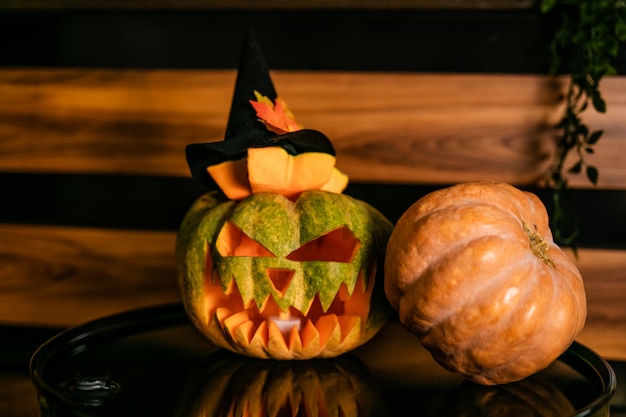 Foto halloween-kürbise mit schwarzem hexenhut