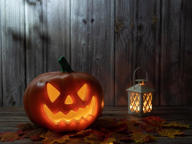 Foto halloween-kürbiskopflaterne mit kerzen und kürbis auf holzhintergrund