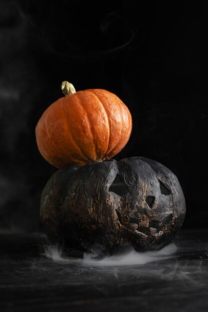 Halloween-Kürbisse auf dunklem Hintergrund in Rauch