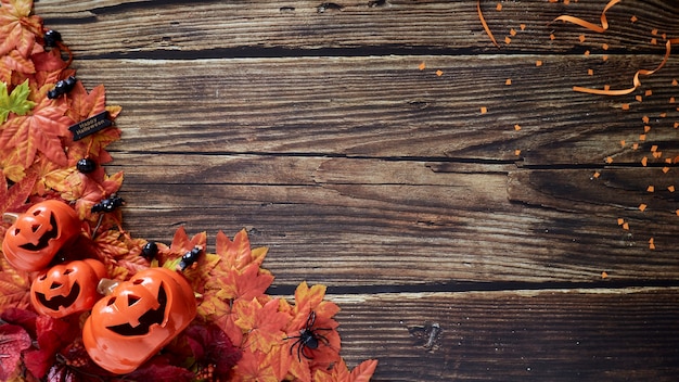 Halloween-Kürbisse mit Herbstherbstblättern über Holz