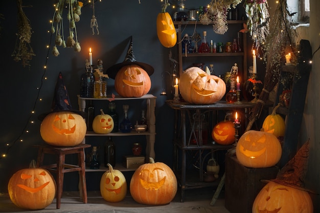 Halloween Kürbisse mit Lichtern und brennenden Kerzen und Zaubertränken im Hexenhaus