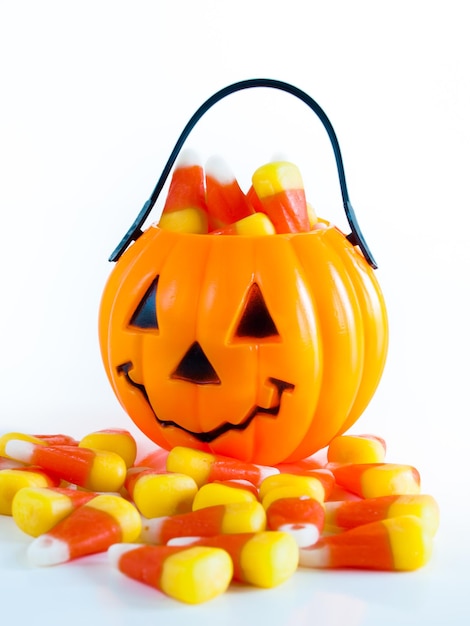 Halloween-Leckerei-Tasche gefüllt mit Candy Corn Bonbons auf weißem Hintergrund.
