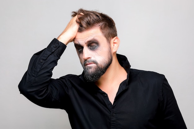 Halloween y maquillaje para un hombre barbudo que se arranca el pelo de la cabeza