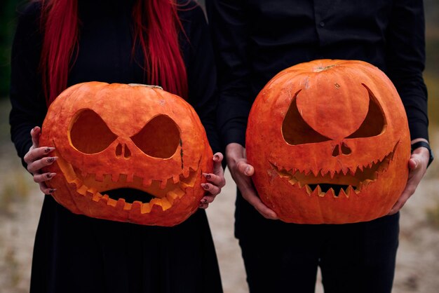 Halloween menino e menina com abóboras em suas cabeças