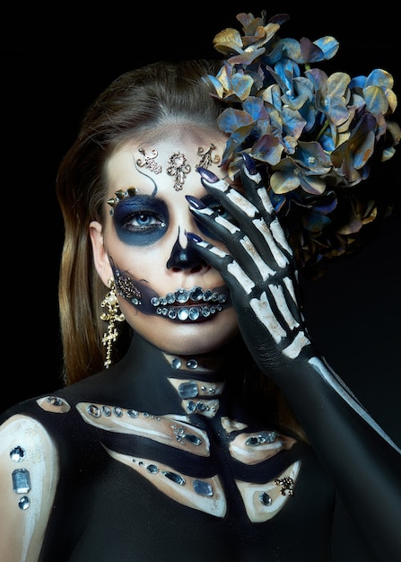 Foto halloween-schönheitsporträt einer skelettfrau des todes, das make-up im gesicht. mädchen tod halloween-kostüm. tag der toten. charmante und gefährliche calavera catrina