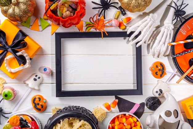 Halloween-Süßigkeiten und Snacks-Tisch Set von Halloween-Dinner-Party-Lebensmitteln Süßigkeiten-Snacks mit Weihnachtskostümdekorationen Kürbiss-Eimer Holz-Hintergrund Top-View-Kopierraum