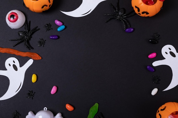 Halloween-Süßigkeiten und Spielzeug mit Copy-Raum auf grauem Hintergrund. Halloween-Festival und Feierkonzept