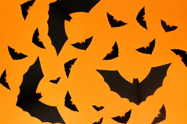 Halloween-Symbolkonzept Silhouette des fliegenden Horrors große schwarze Fledermaus auf orangefarbenem Hintergrund