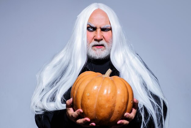Halloween-Teufelsmann mit bärtigem Kürbismann im Hexerkostüm, bereit zum Feiern