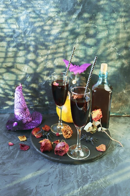 Halloween Wein in Gläsern und eine Flasche Kürbisse mystische Dekorationen trockene Rosenblüten