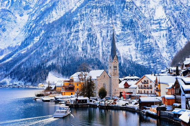 Hallstatt bei Salzburg, in Österreich, Europa. Winter im Salzkammergut. Reisen Sie zu Weihnachten in die österreichische Stadt mit See. Alpenland mit Schnee. Blick auf das Dorf in der Nähe der Alpenberge mit schöner Kirche.