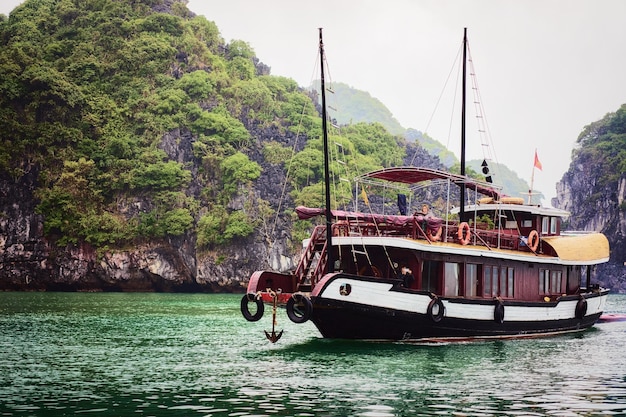 Halong, Vietnam - 23. Februar 2016: Kreuzfahrtschiff auf Ha Long Bay, Vietnam. Kalksteininseln im Hintergrund