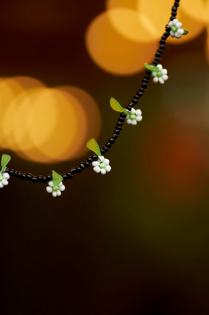 Halskette mit grünen und schwarzen Perlen und weißen Blumen. Perlenperlen. Schöne, stilvolle Perlen