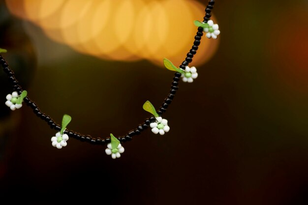 Halskette mit grünen und schwarzen Perlen und weißen Blumen. Perlenperlen. Schöne, stilvolle Perlen