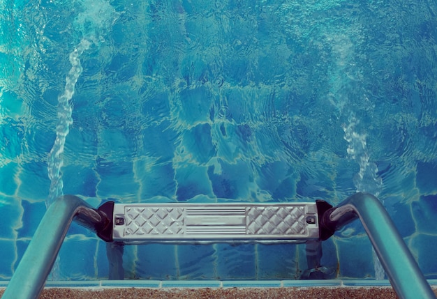 Haltegriffleiter im blauen Swimmingpool.