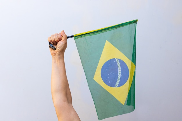 Halten der Brasilien-Flagge isoliert auf weißem Hintergrund. Flagge und Unabhängigkeitstag-Konzept-Bild.