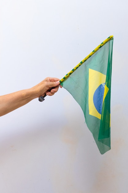 Halten der Brasilien-Flagge isoliert auf weißem Hintergrund. Flagge und Unabhängigkeitstag-Konzept-Bild.