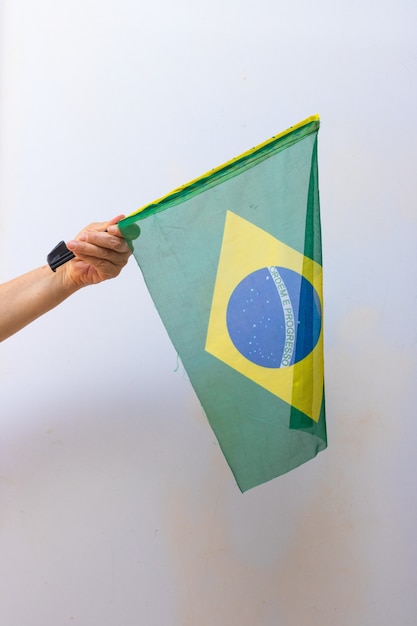 Halten der Brasilien-Flagge isoliert auf weißem Hintergrund. Flagge und Unabhängigkeitstag-Konzept-Bild.