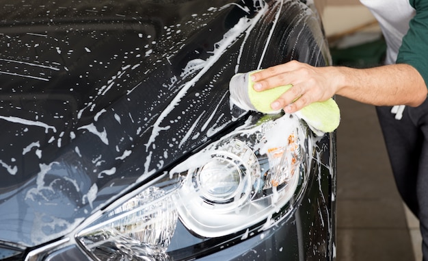 Halten Sie den Schwamm von Hand zum Waschen über das Auto