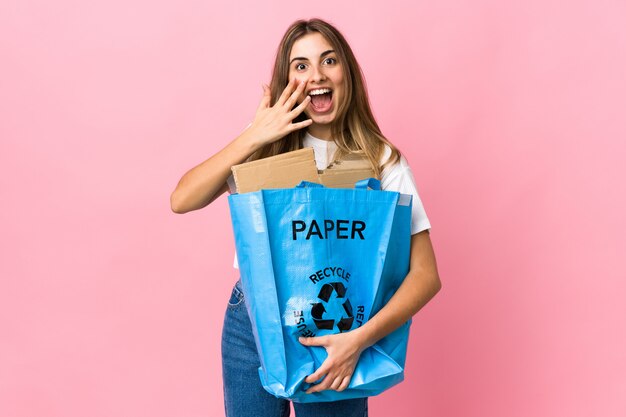 Halten Sie eine Recycling-Tasche voller Papier, um über Pink mit überraschendem Gesichtsausdruck zu recyceln