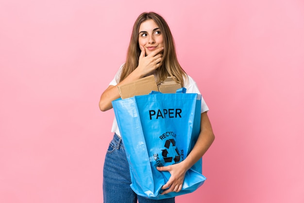 Halten Sie einen Recyclingbeutel voller Papier, um über rosa zu recyceln, denken Sie an eine Idee