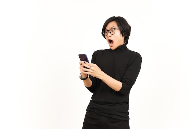 Halten und Verwenden von Smartphone mit schockiertem Gesicht eines gutaussehenden asiatischen Mannes, Isolated On White Background